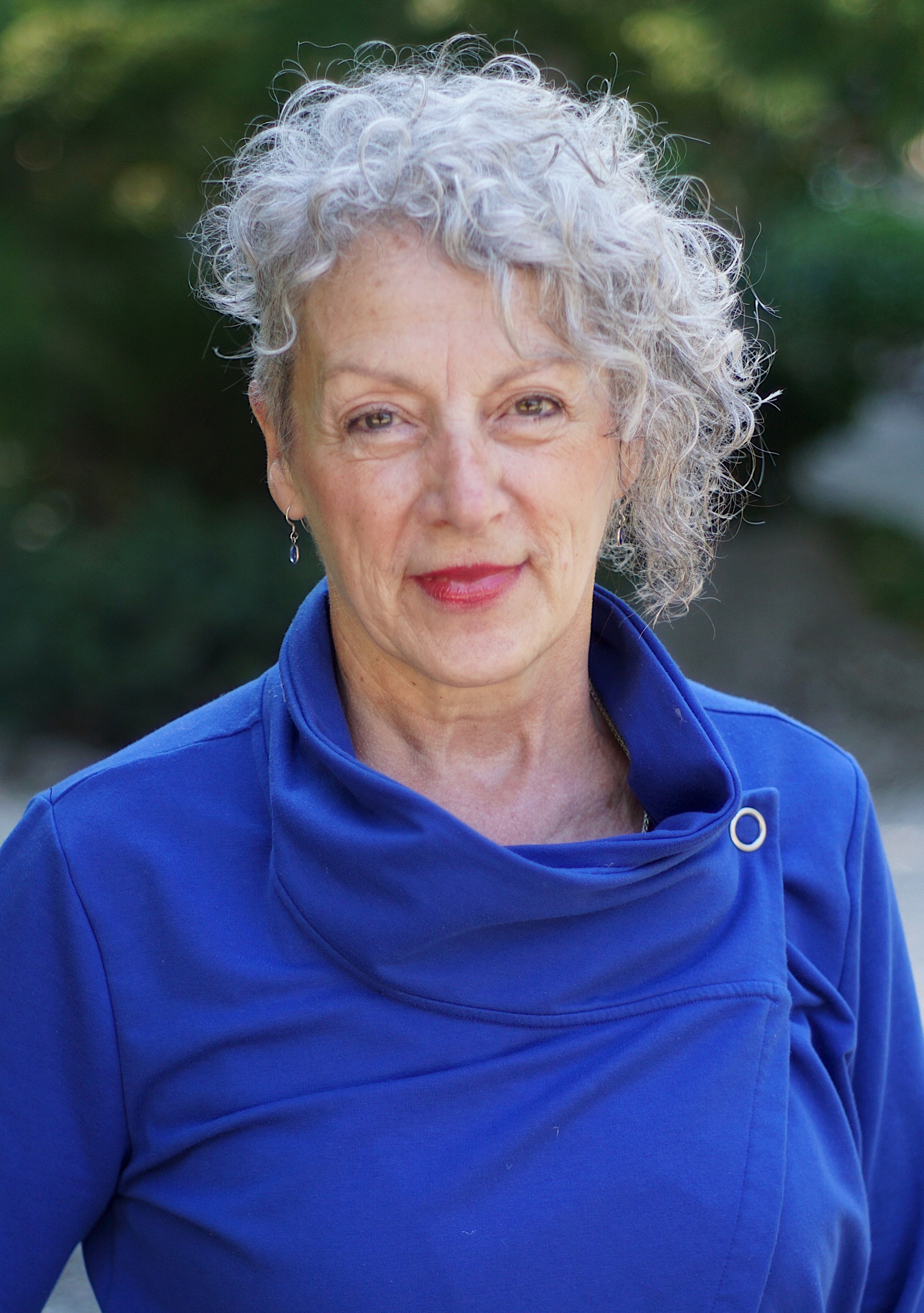 Headshot of Leslie Payne, an older white woman with short silver curly hair in a blue top.